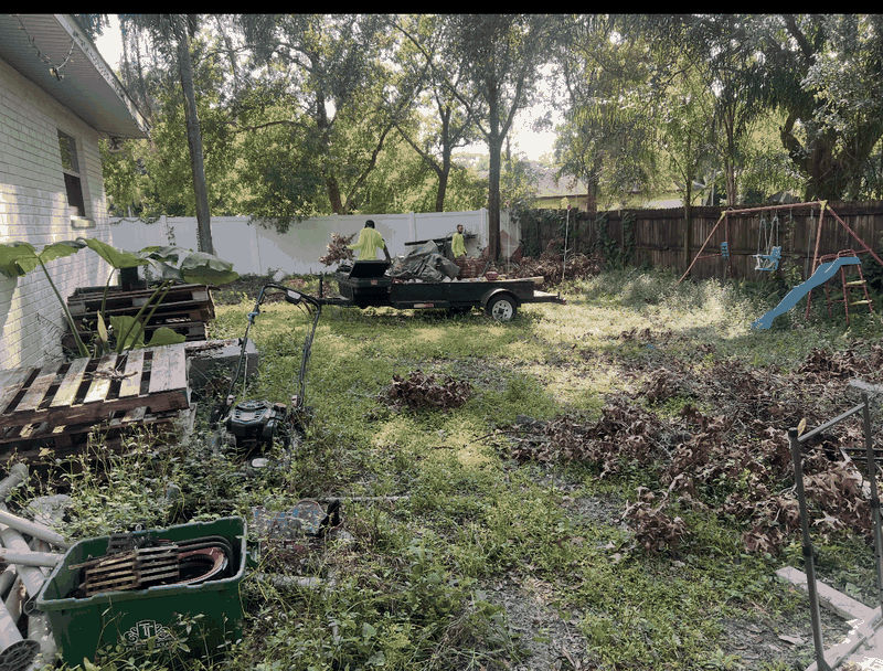 Real job photo: crew loading yard debris into a junk-removal trailer